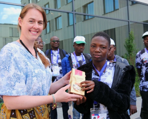 Eine der Organisatoren des Landkreises Coburg übergibt Schokolade an eine der Sportlerinnen aus Togo.